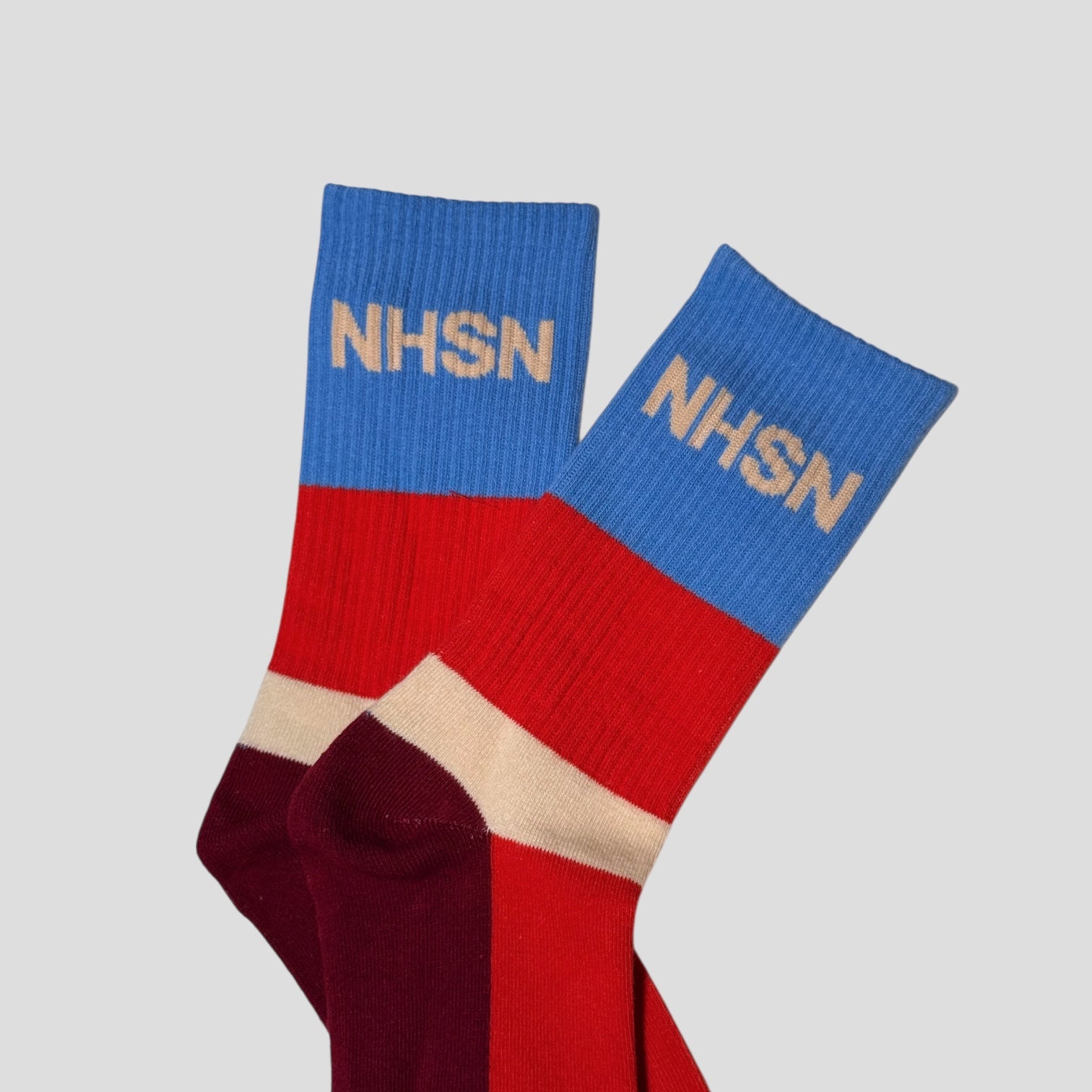 Colorful socks with 'NHSN' branding on a light gray background